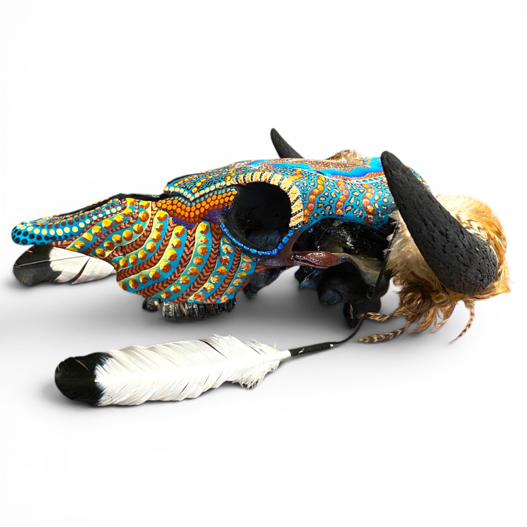 Decorative animal head with colorful patterns and feathers on a white background